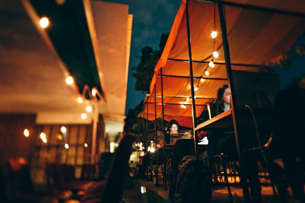 people sitting on chair outside the restaurant during nighttime